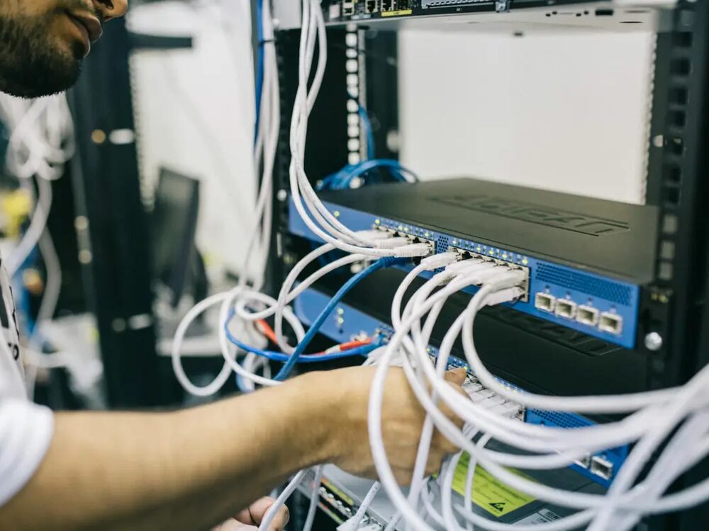 Technician patching network cables into a switch